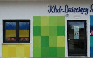 Widok na budynek klubu dziecięcego, w oknie flaga Ukrainy.